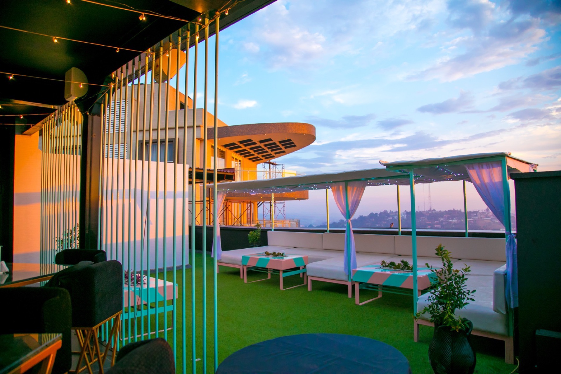 Guests gathered on the glass terrace at sunset high above Kampala